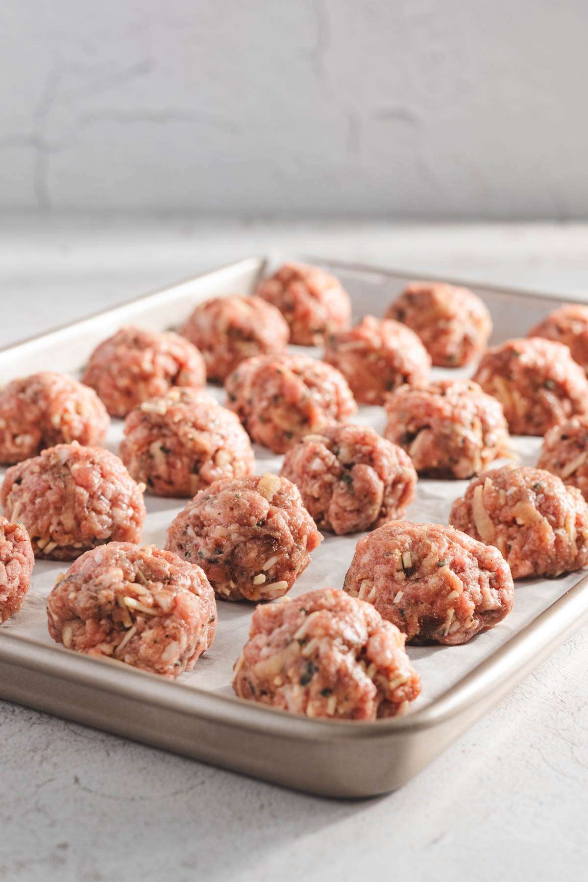 raw meatballs on a baking sheet