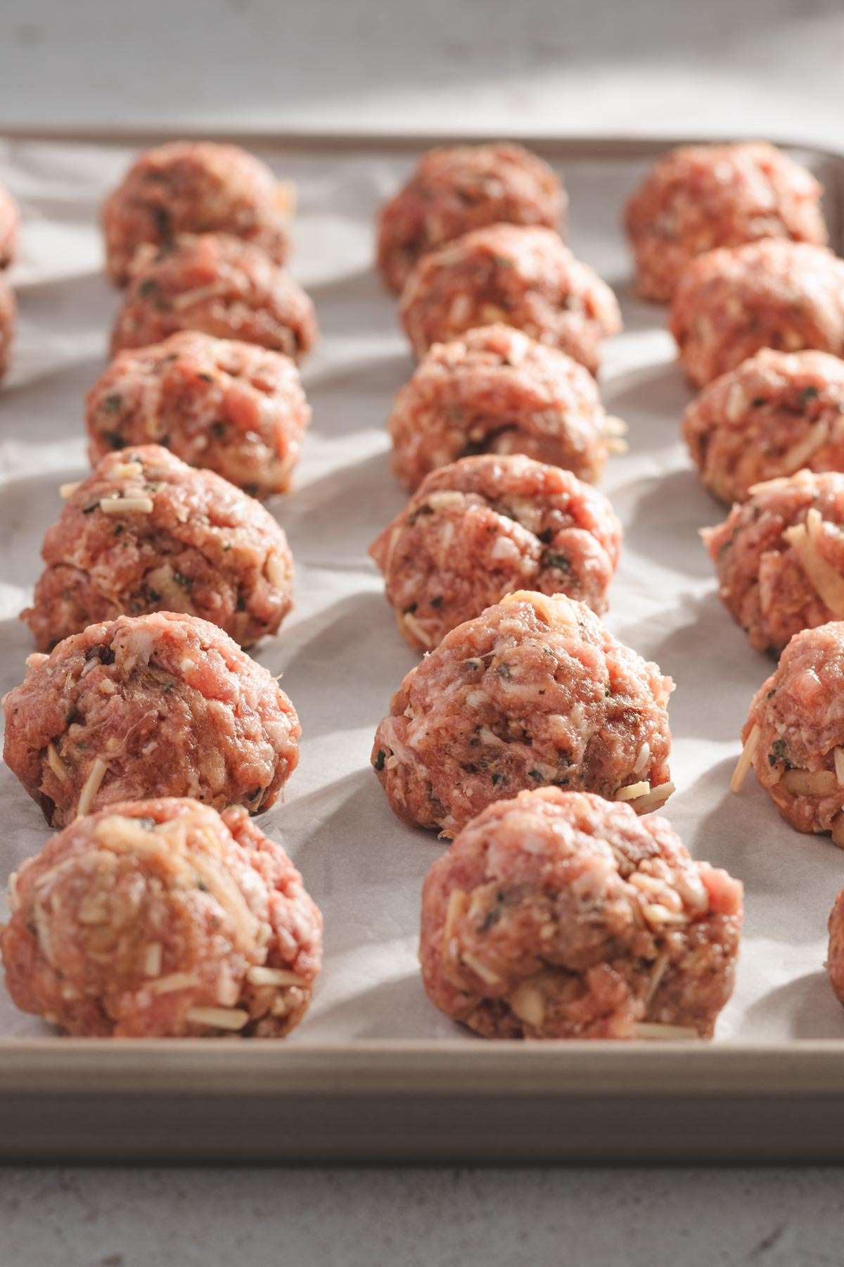 raw meatballs on a baking sheet