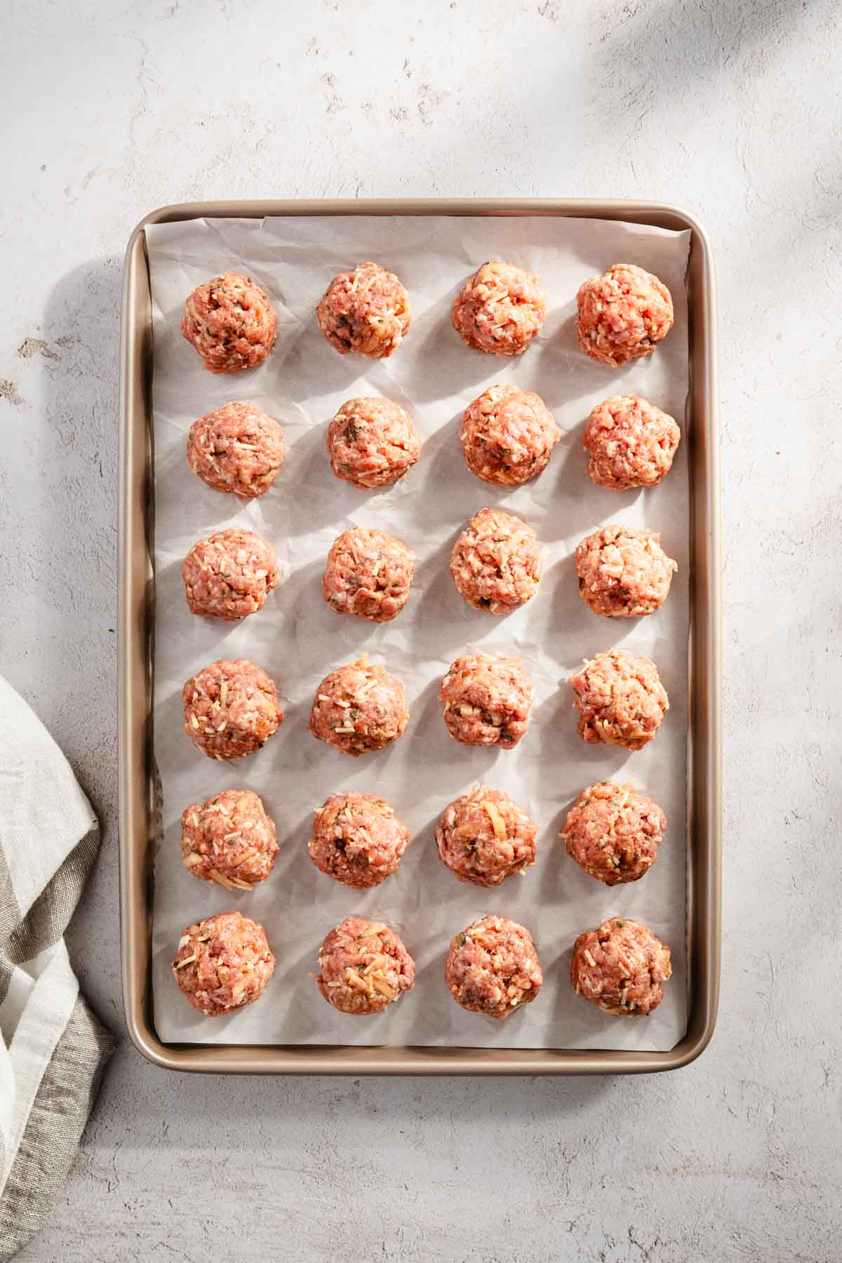 raw meatballs on a baking sheet