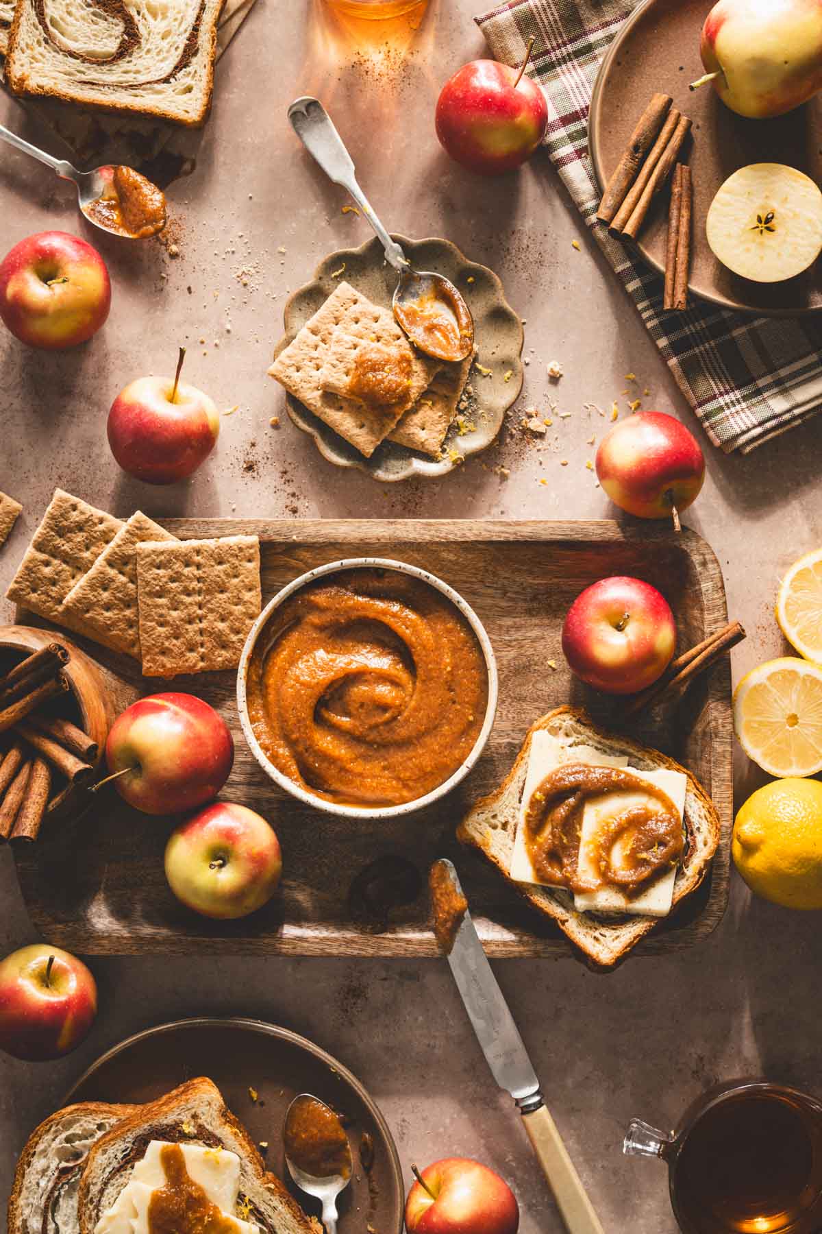 ple butter on a serving board, fresh apples, cinnamon sticks, slices of bread