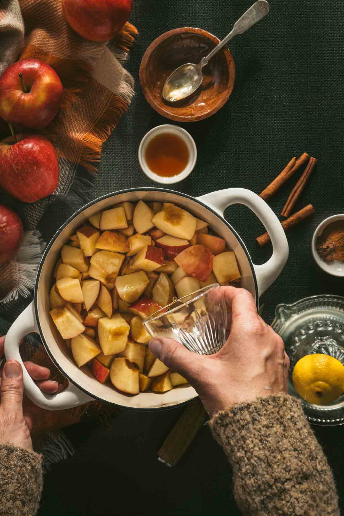 adding juice to cut apples in the saucepan