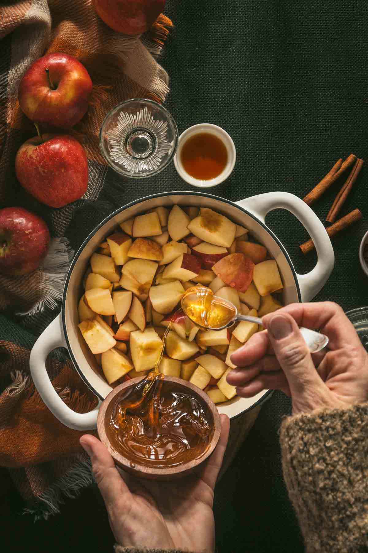 adding honey to cut apples in the sauce pan