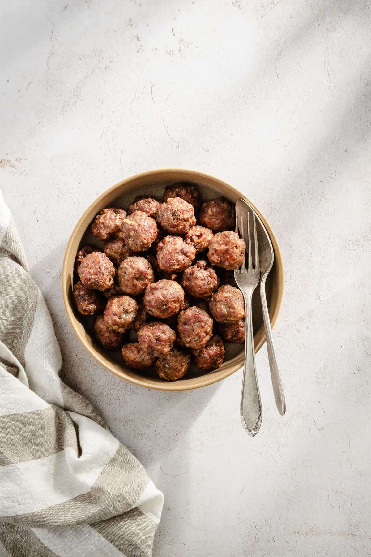 meatballs in a bowl with fork and spoon