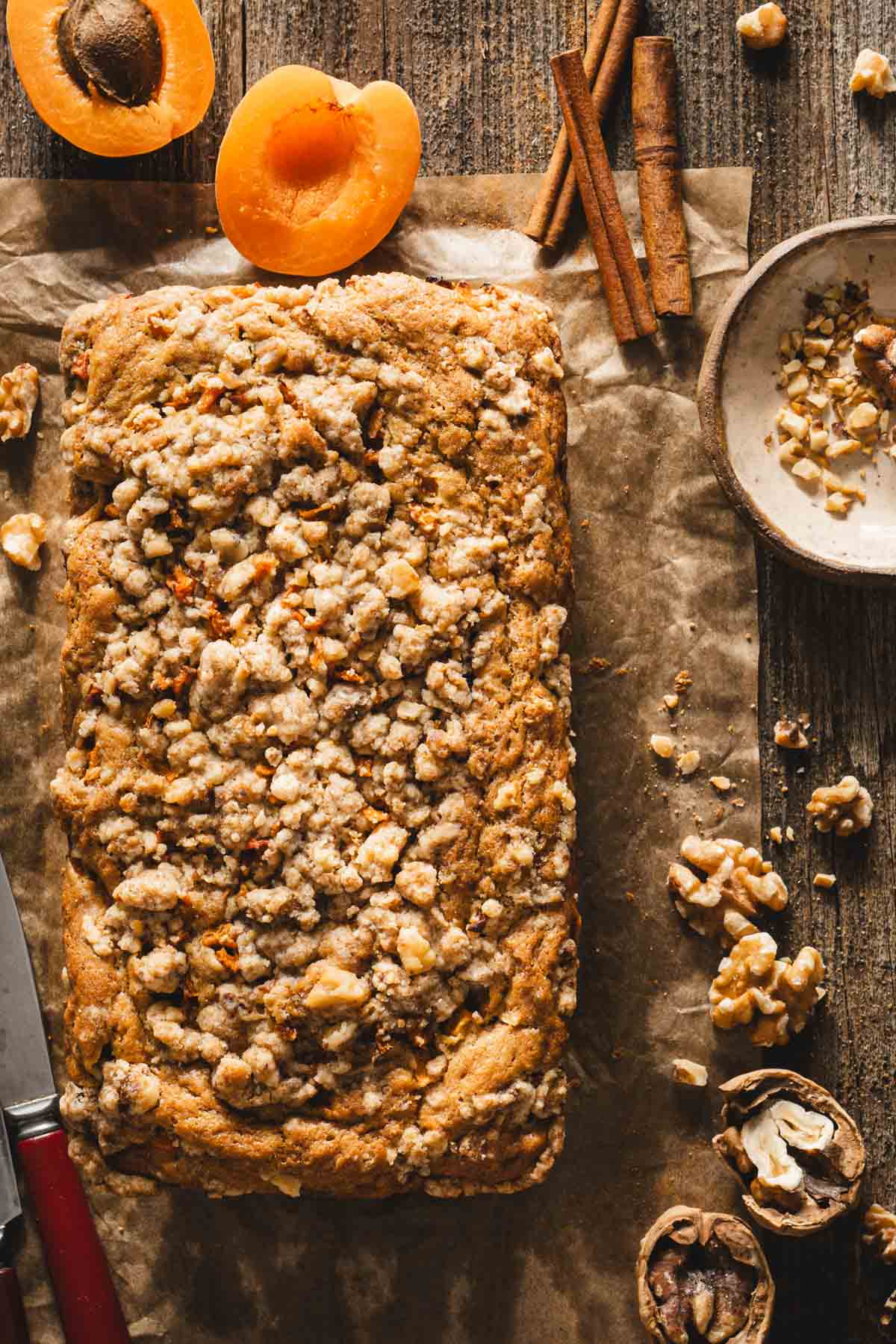 top view of the bread on a wooden board, fresh apricots, dish with walnuts