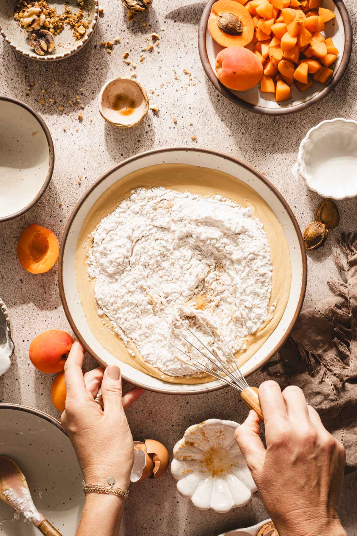 hands in frame adding flour to the batter