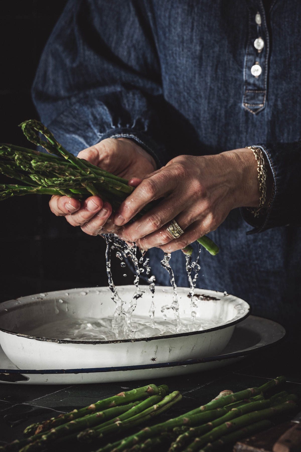 hands in frame washing asparagus