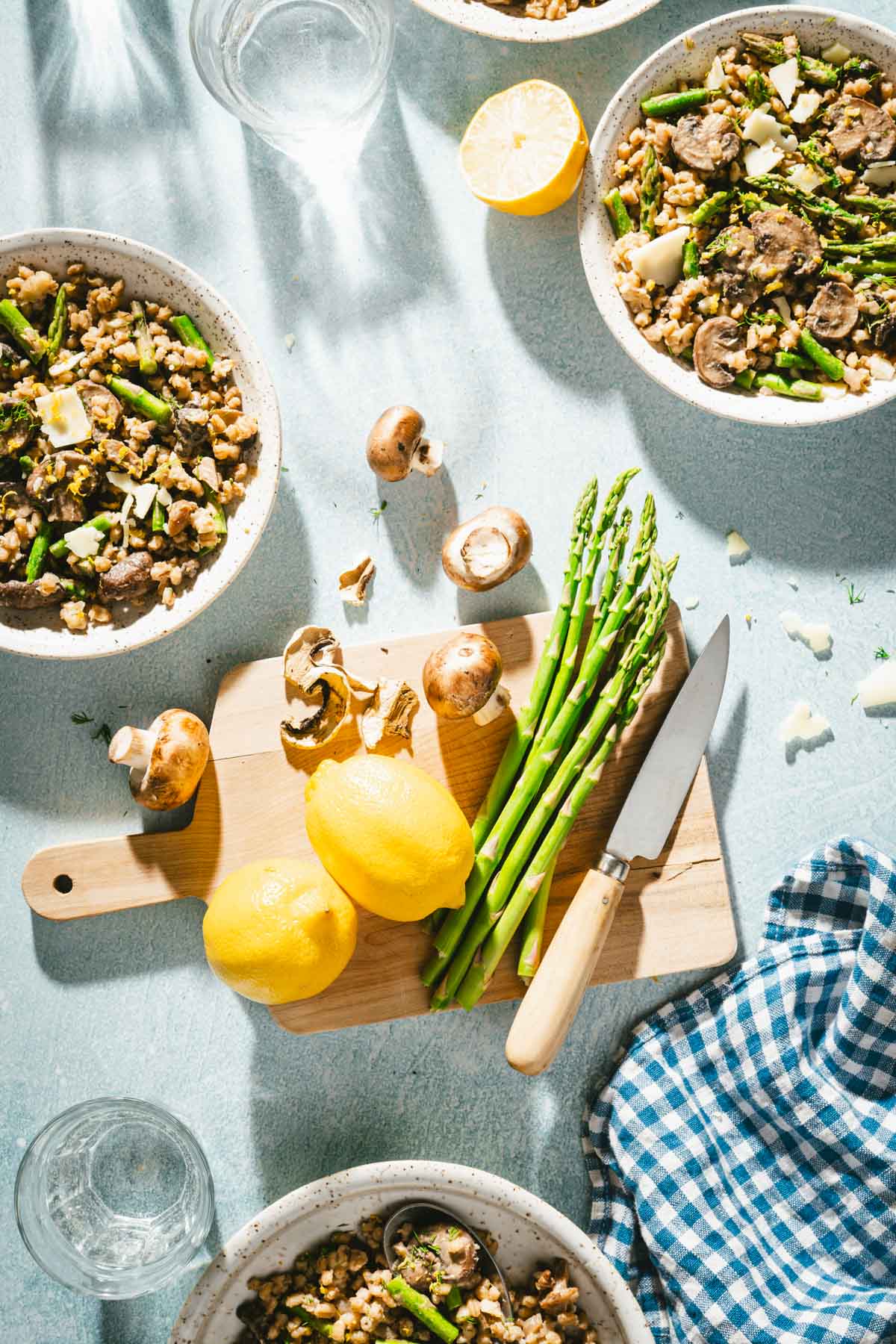 cutting board with asparagus, various serving dishes with the risotto