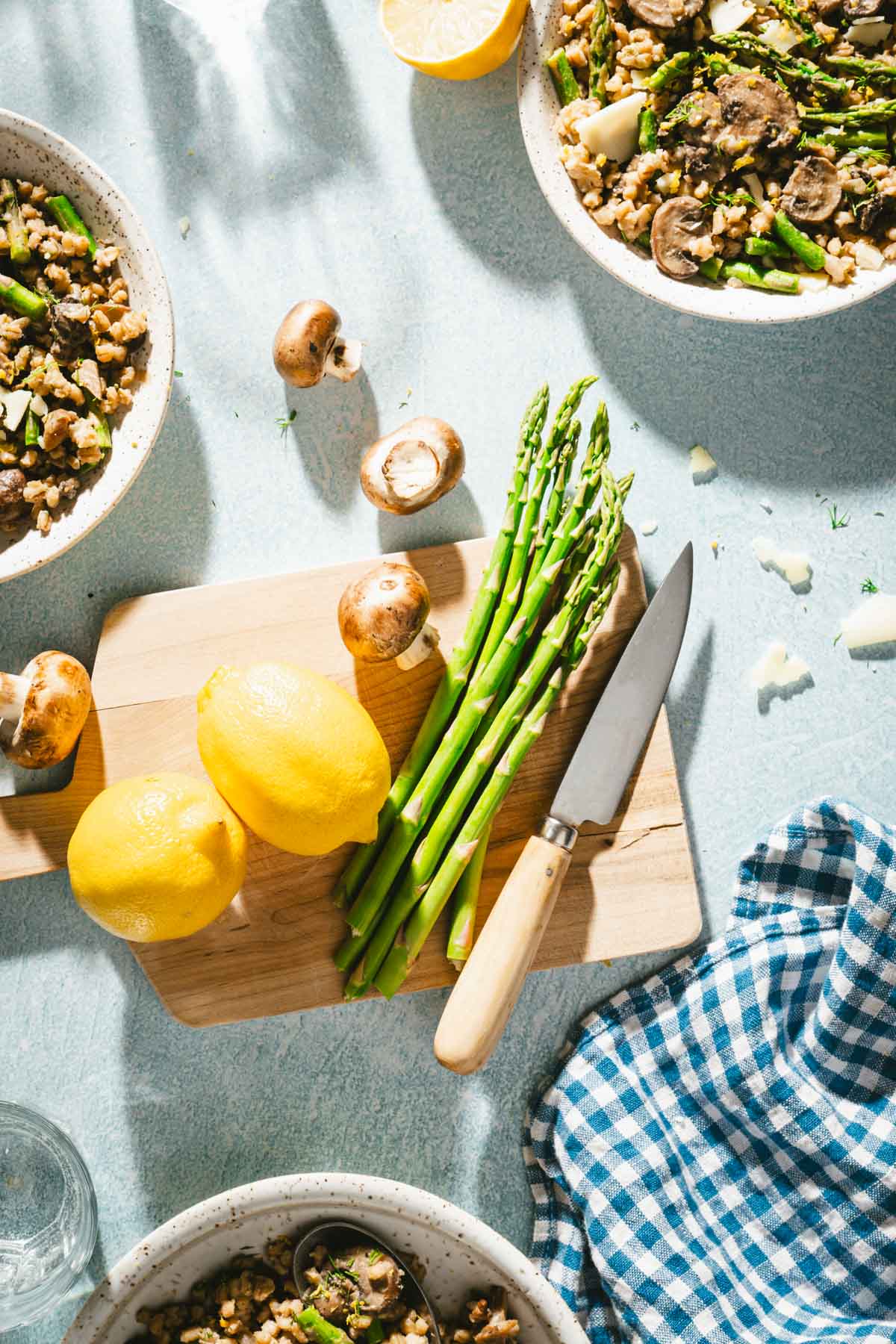 cutting board with asparagus, lemons, mushrooms