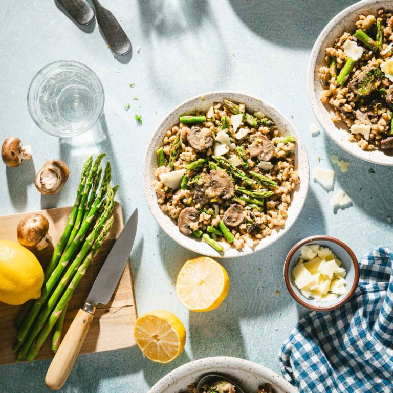 serving bowl with the risotto, cutting board with fresh asparagus