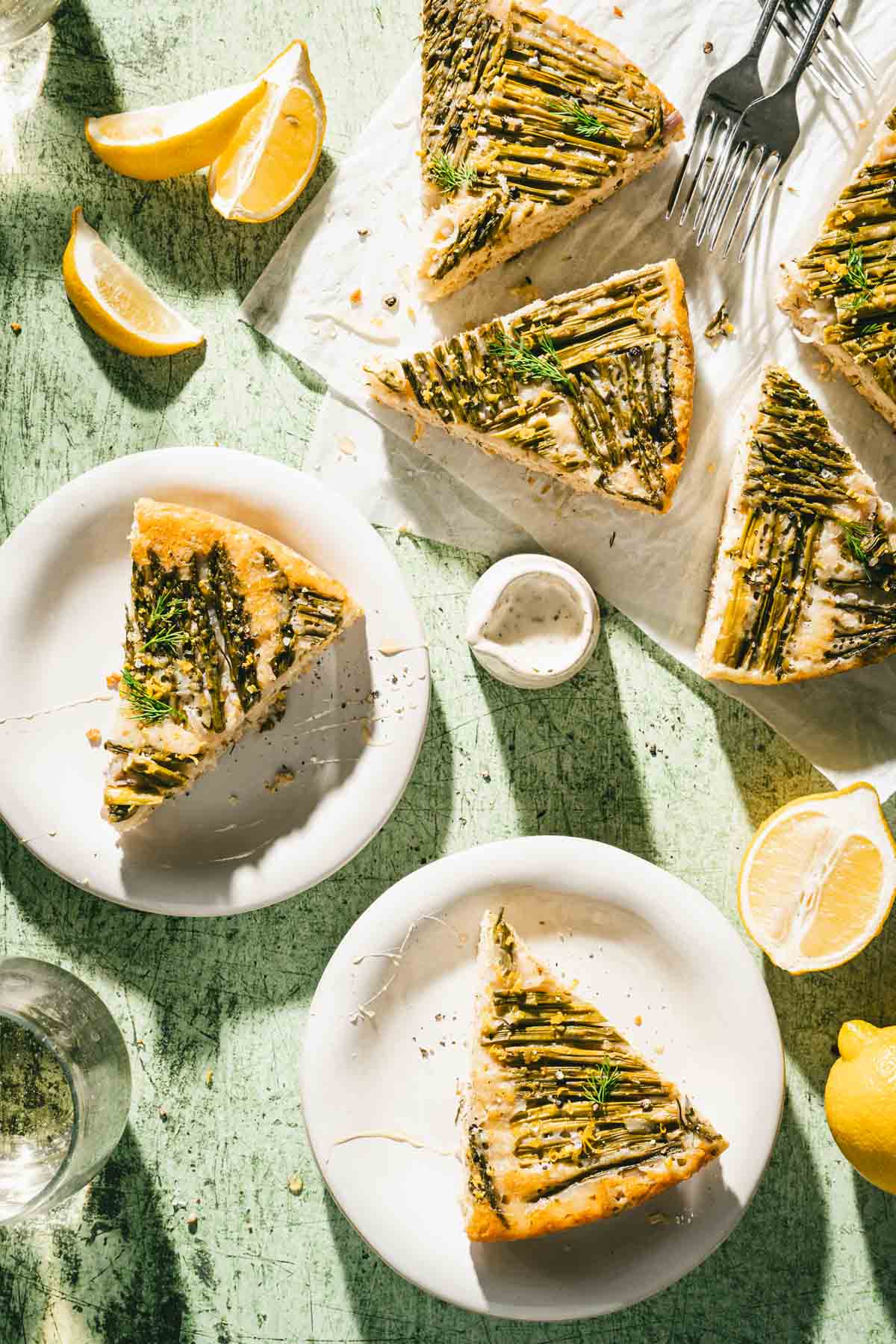 asapragus cake on serving plates, lemon, forks