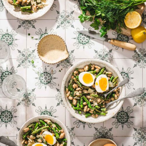 various serving bowls with th asparagus salad