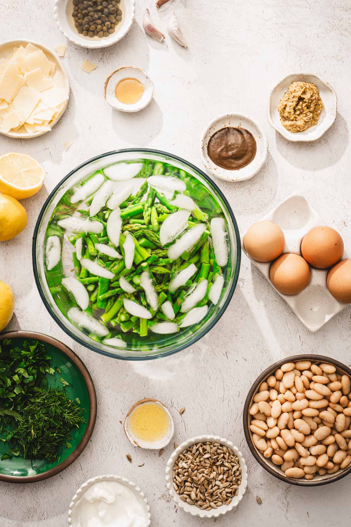 cooked asparagus in a glass bowl with ice water