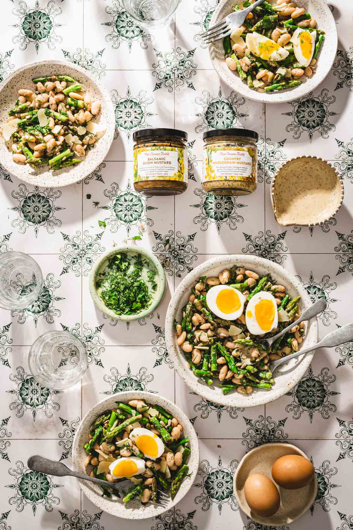 various bowls with the asparagus salad, jars with mustard
