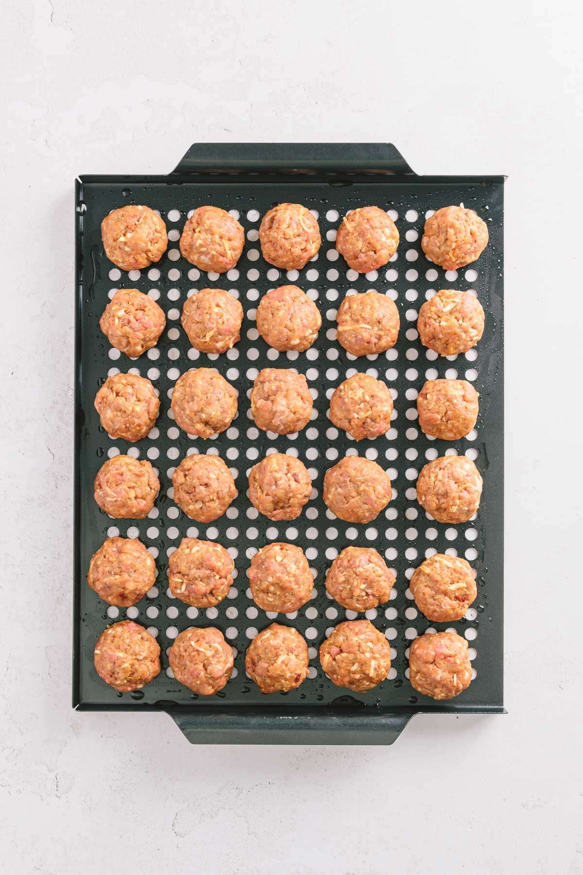 bbq meatballs formed and placed on a grilling tray