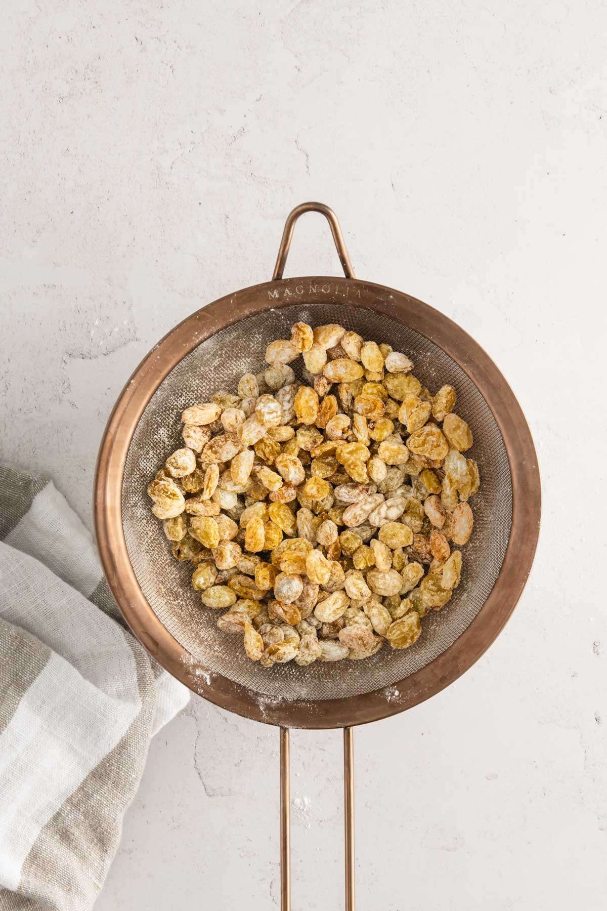 raisins dusted with flour in a strainer