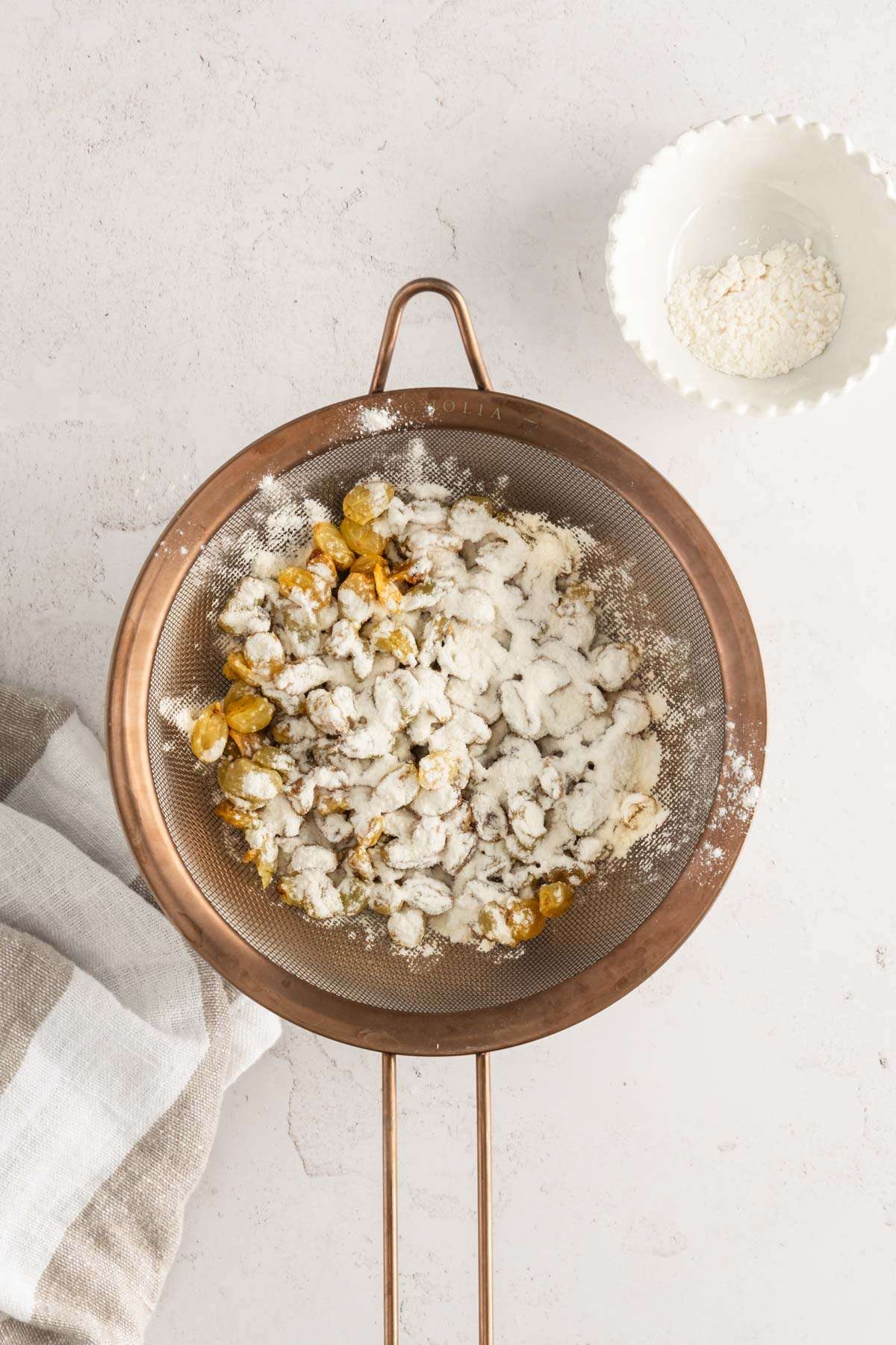 raisins covered in flour in a strainer