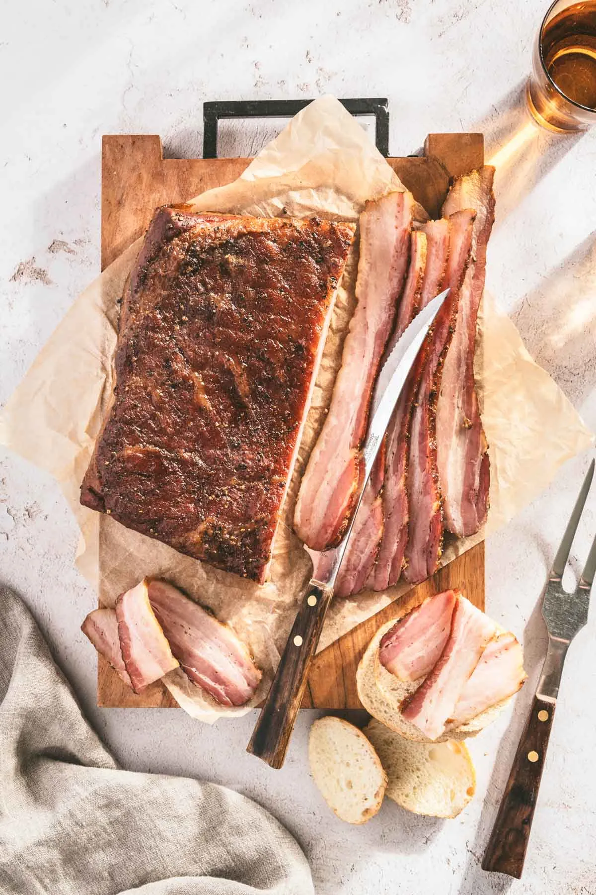 pork belly cooked and sliced; cutting knife and serving fork