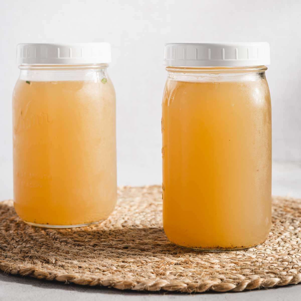 beef bone broth in two mason jars, front view