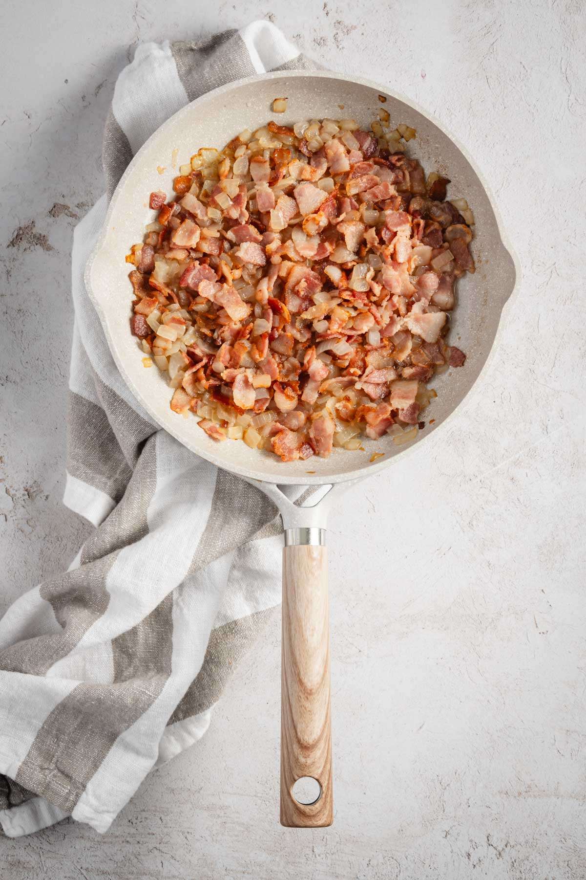 frying pan with chopped bacon and onion, cooked