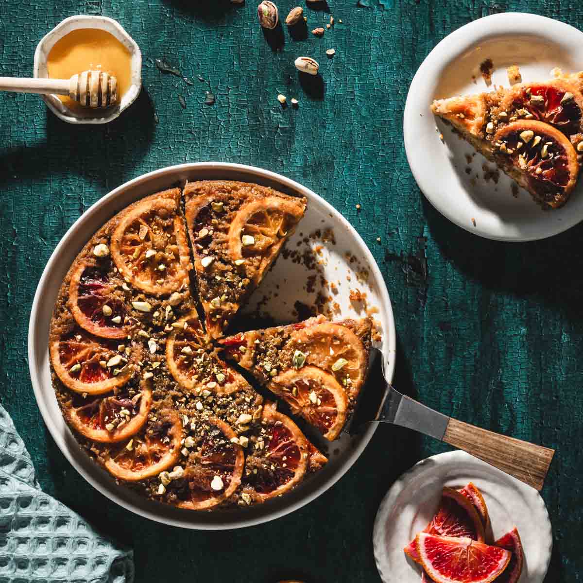finished blood orange cake, slice on a plate, serving spatula