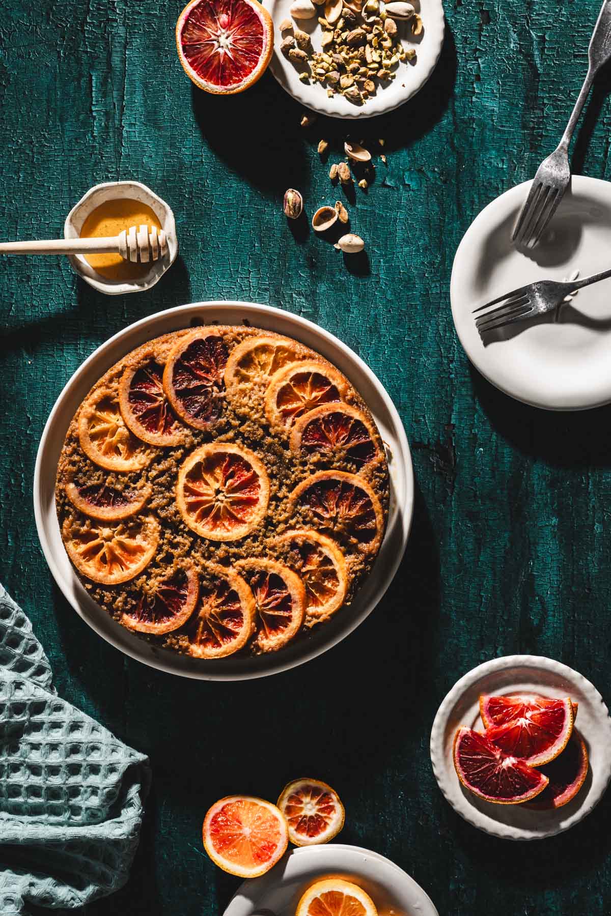 baked cake, various plates, honey, spatula, pistachios