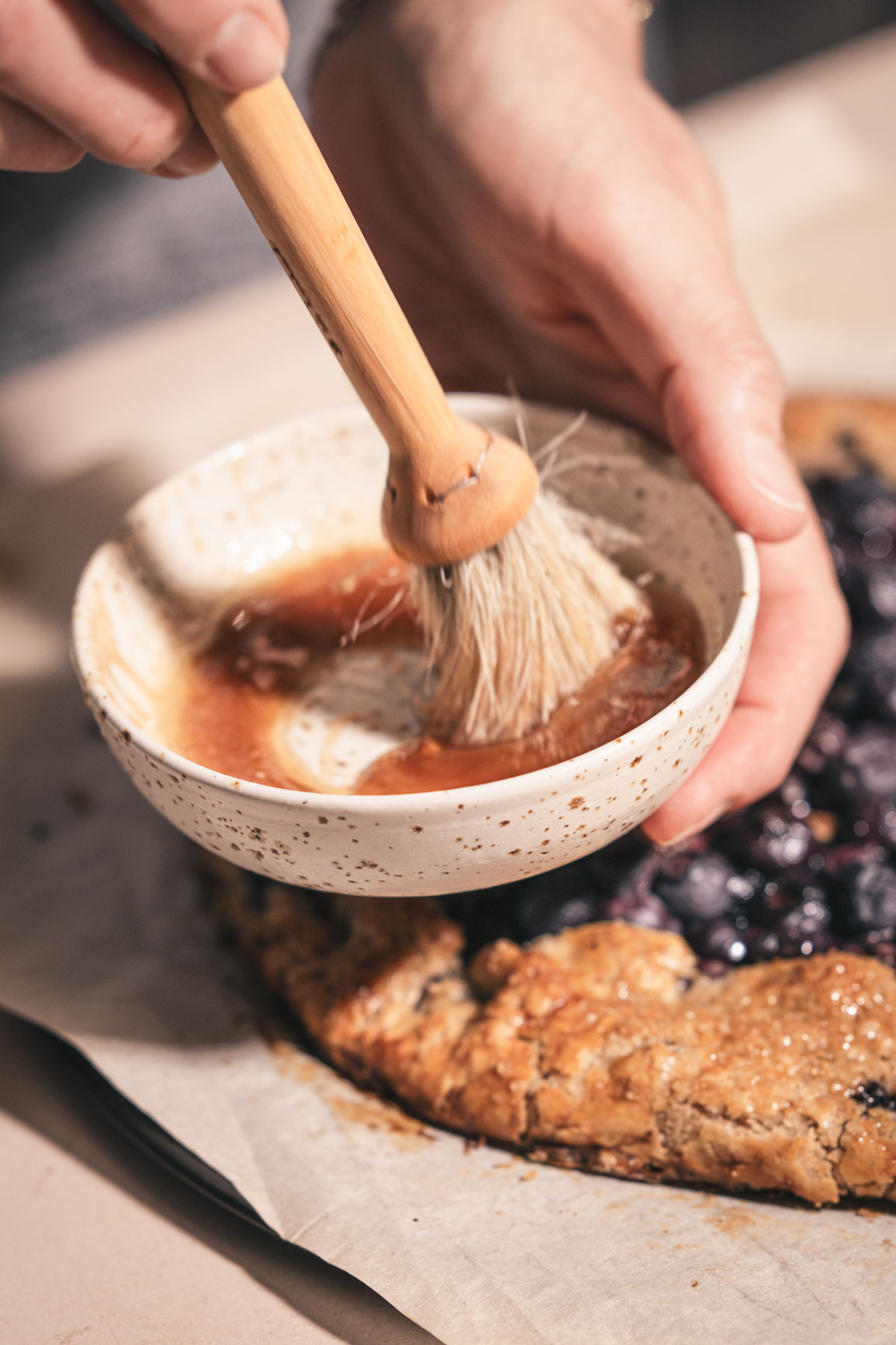 hands in frame holding a brush and a small dish