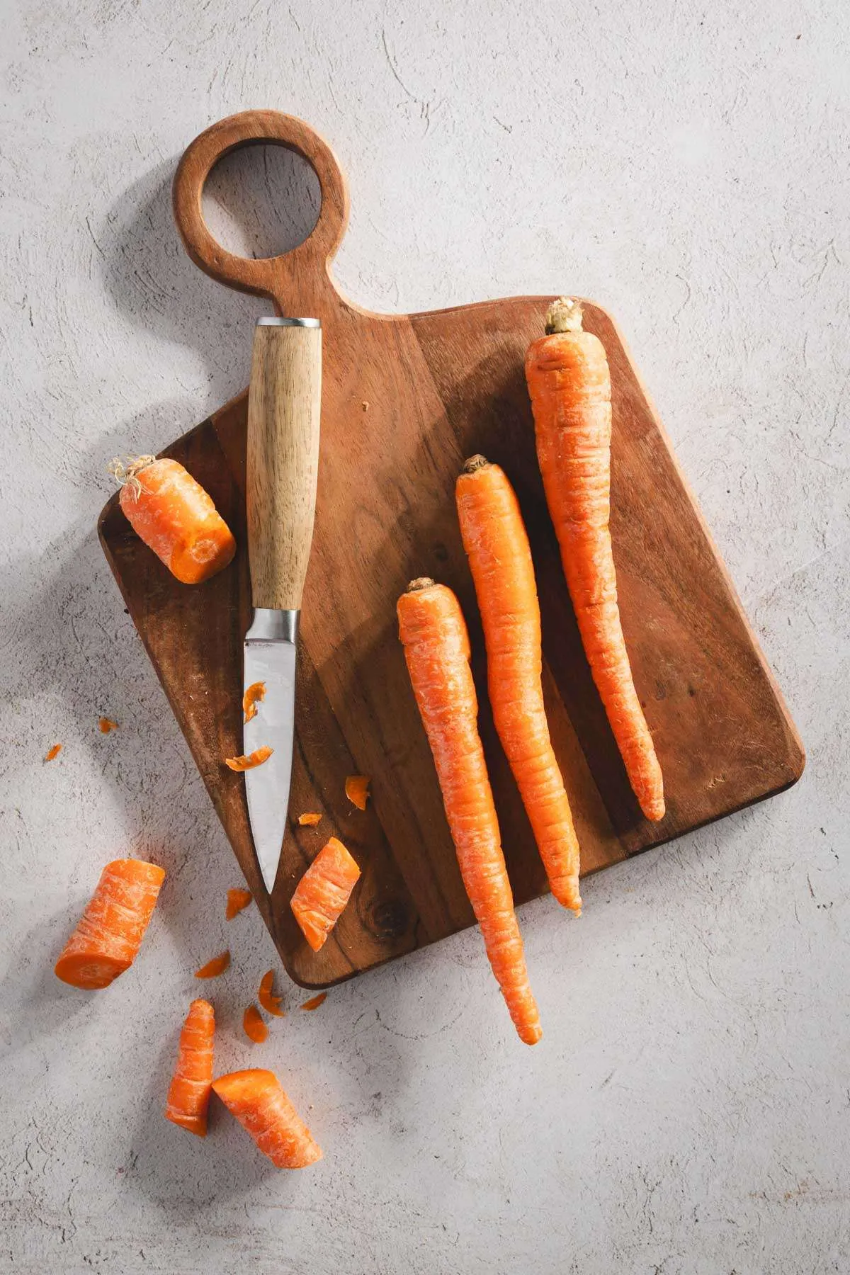 carrots on a cutting board, small knife