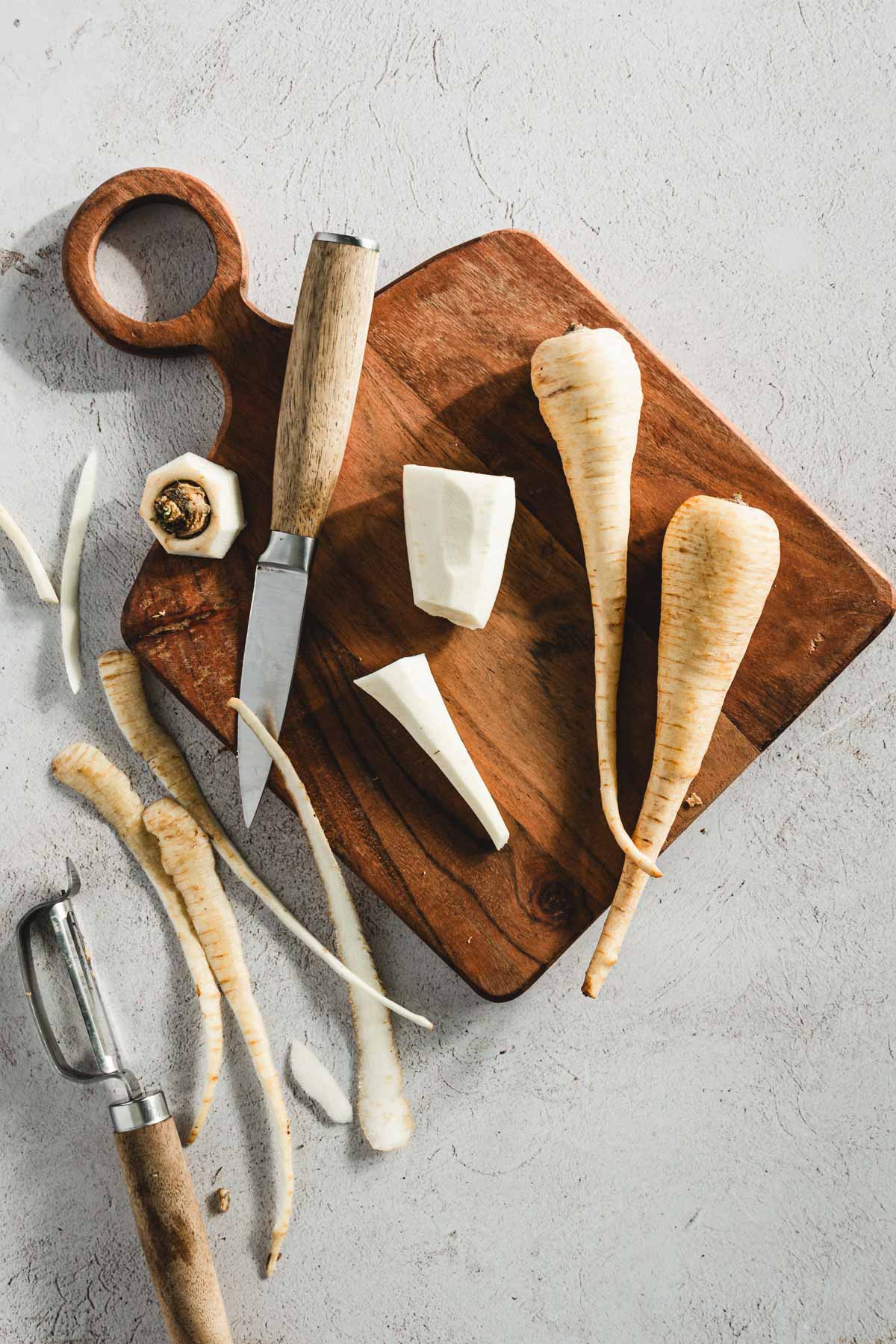 parsnips on a cutting board, small knife