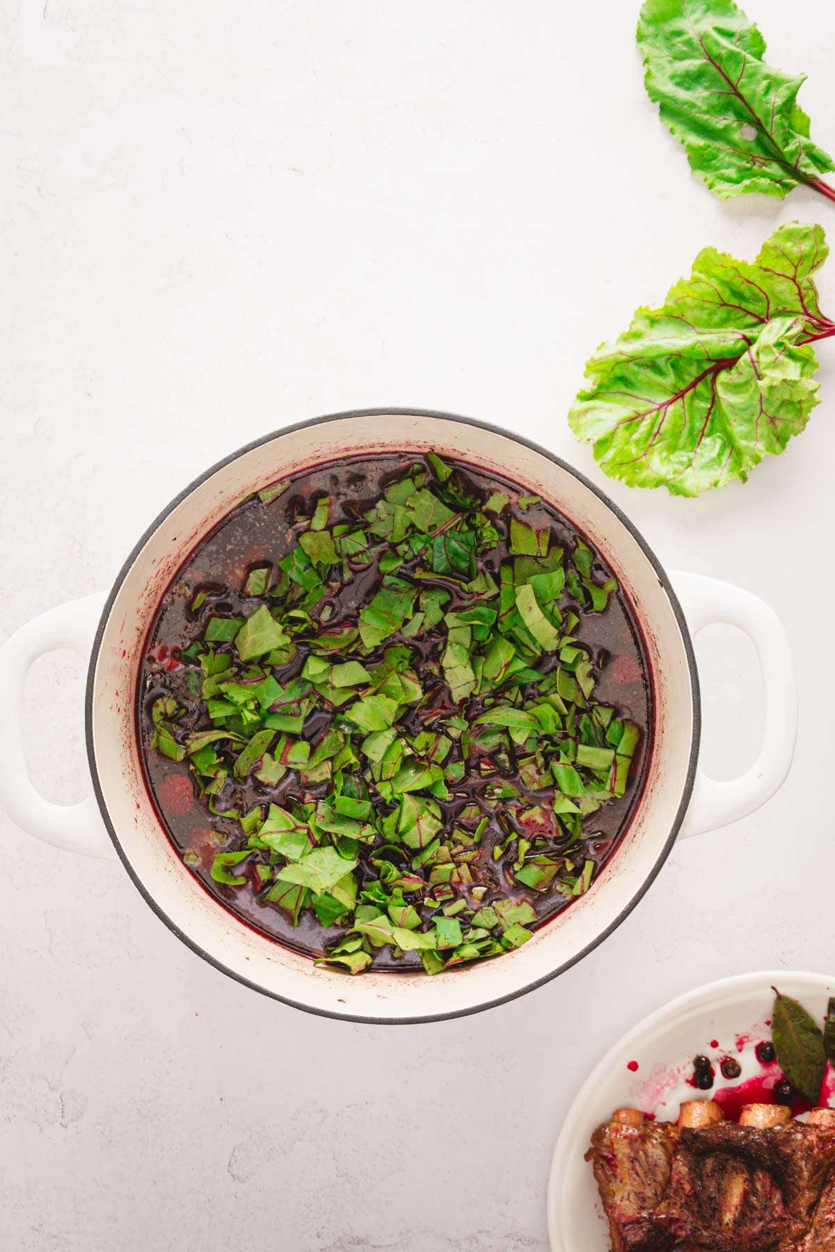 stock pot with cooked botwinka soup with beet leaves added