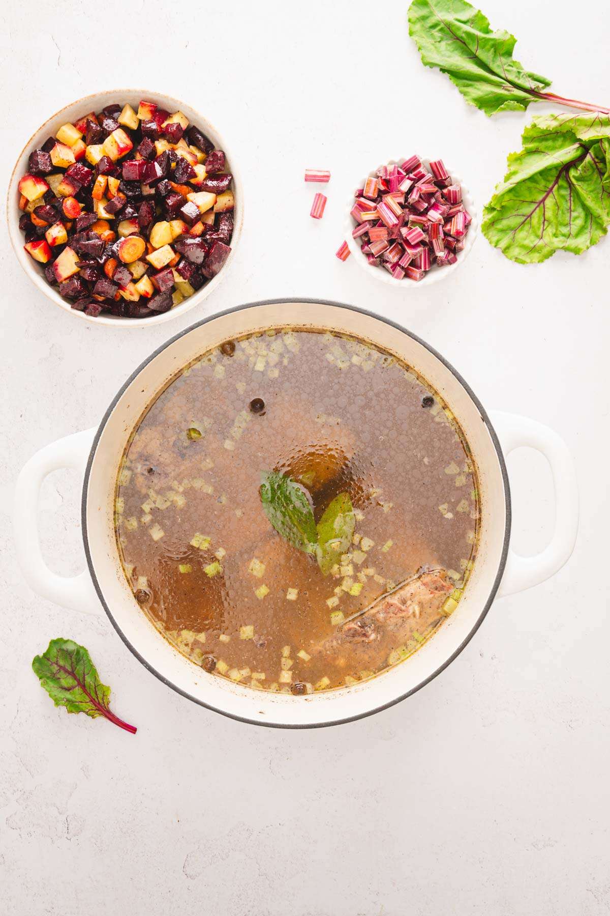 stock pot with the soup, dish with roasted veggies, beet stems, beet leaves