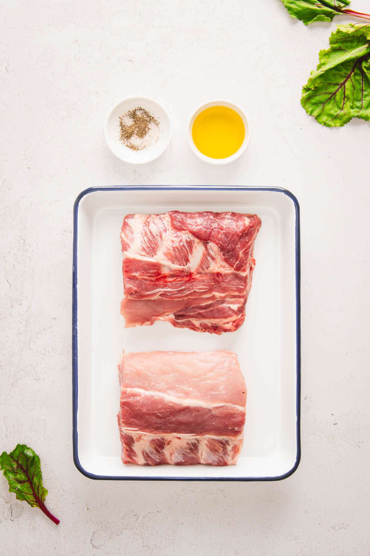 small tray with fresh ribs, dish with oil, salt and pepper