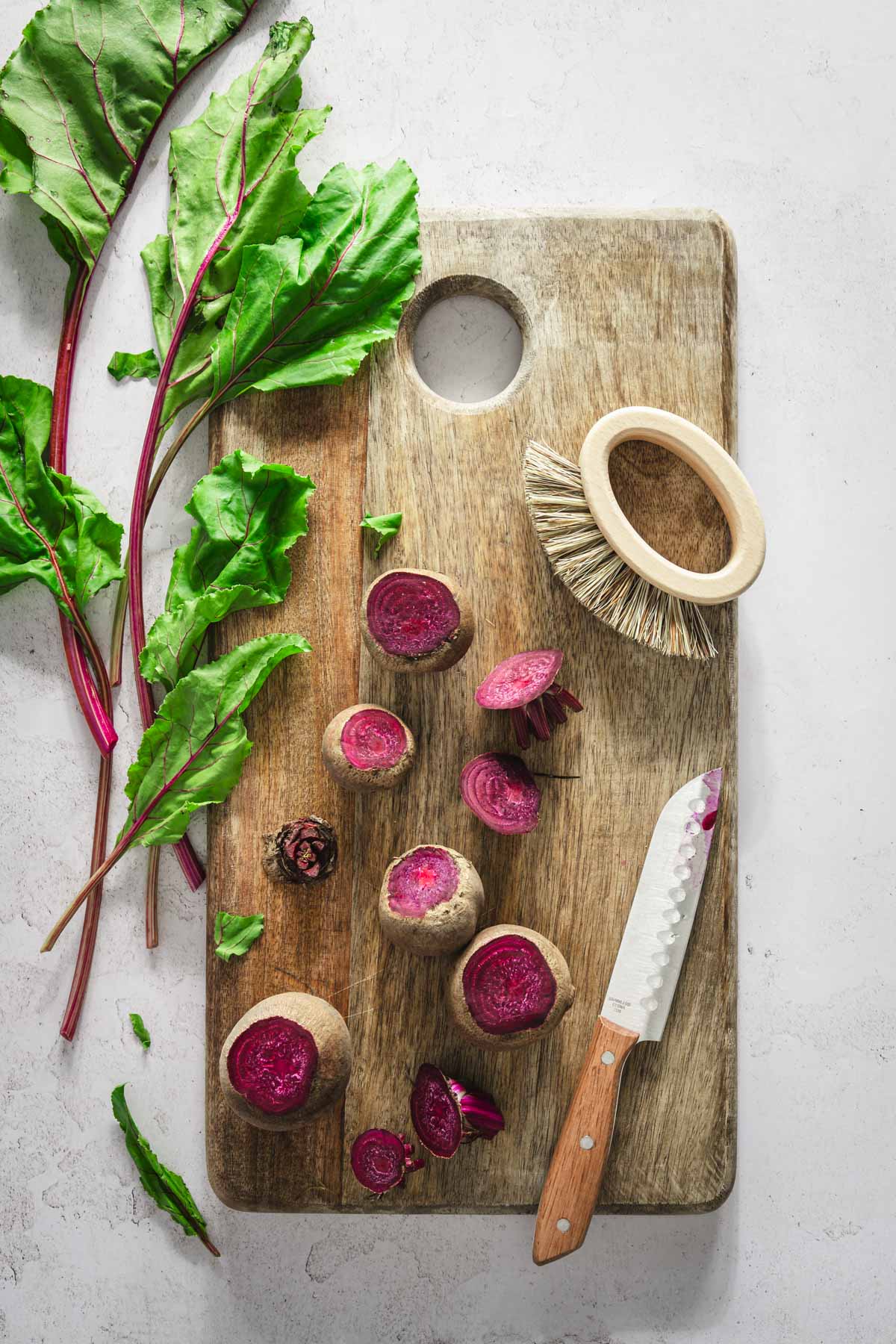 beets on a wooden board, knife, cleaning brush