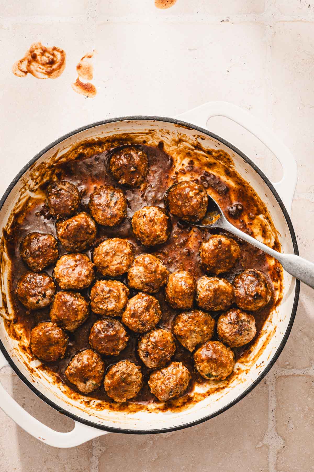 large skillet with browned meatballs in the b ourbon sauce
