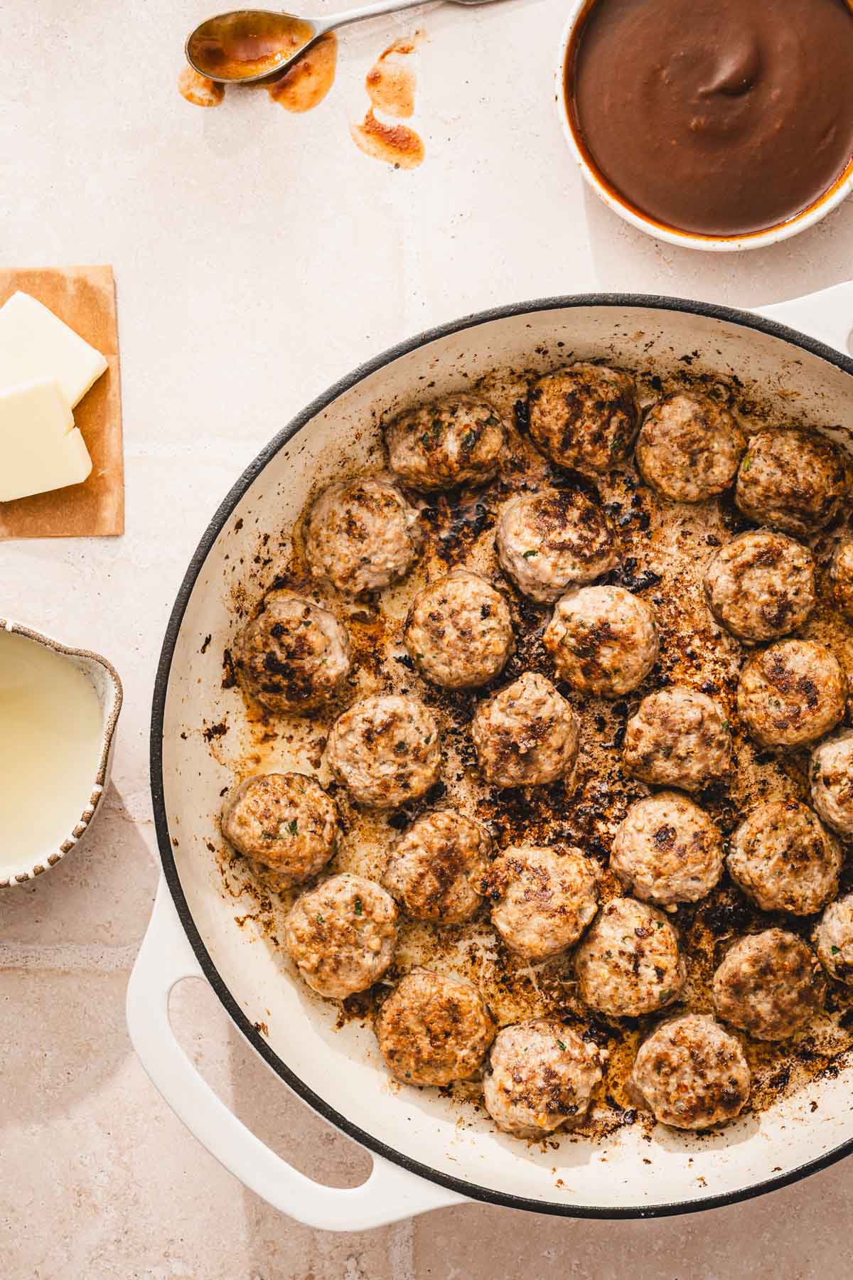 large skillet with browned meatballs