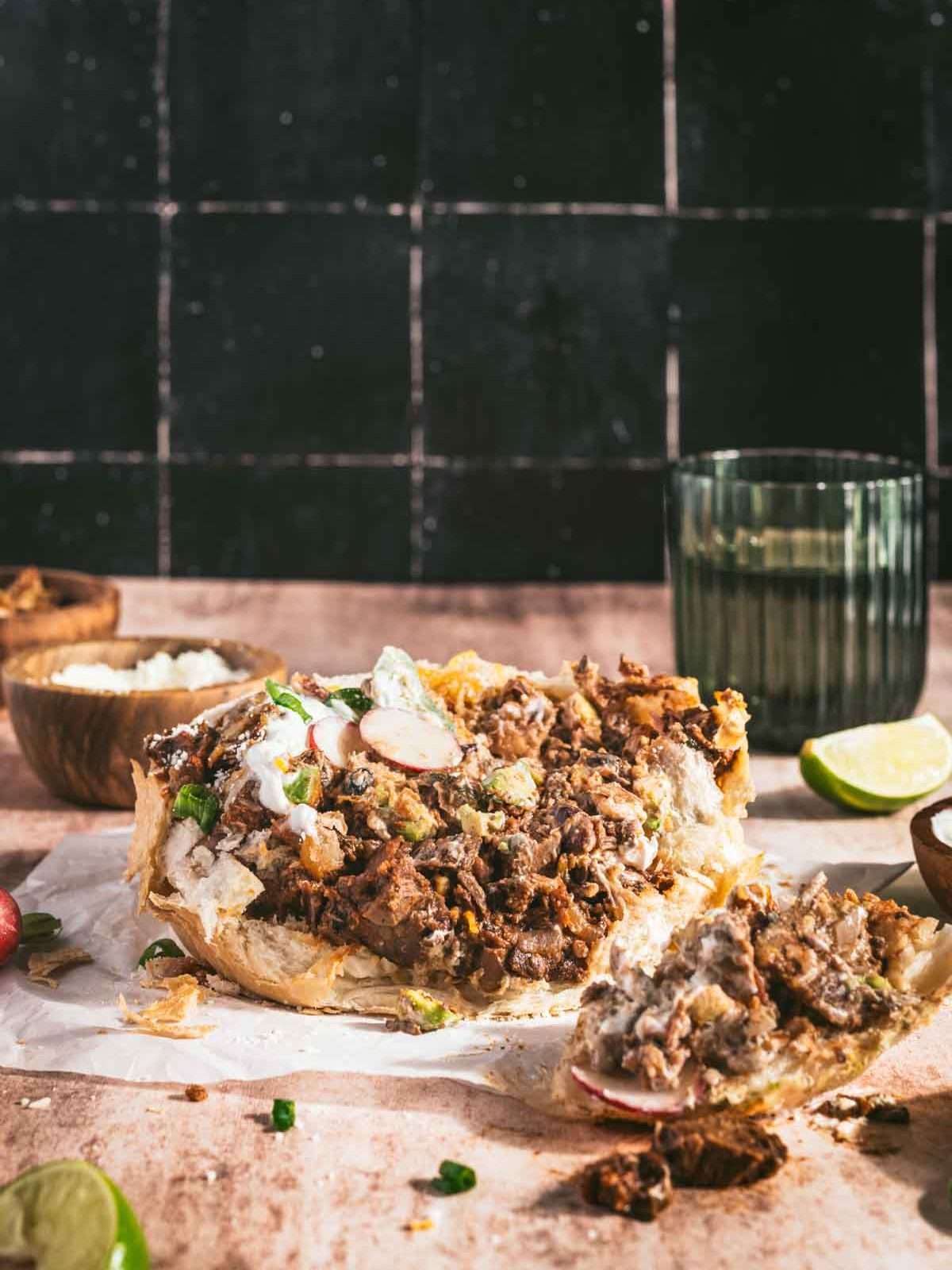 Chili Bread Bowl, glass with water, small dish with sour cream, lime wedges