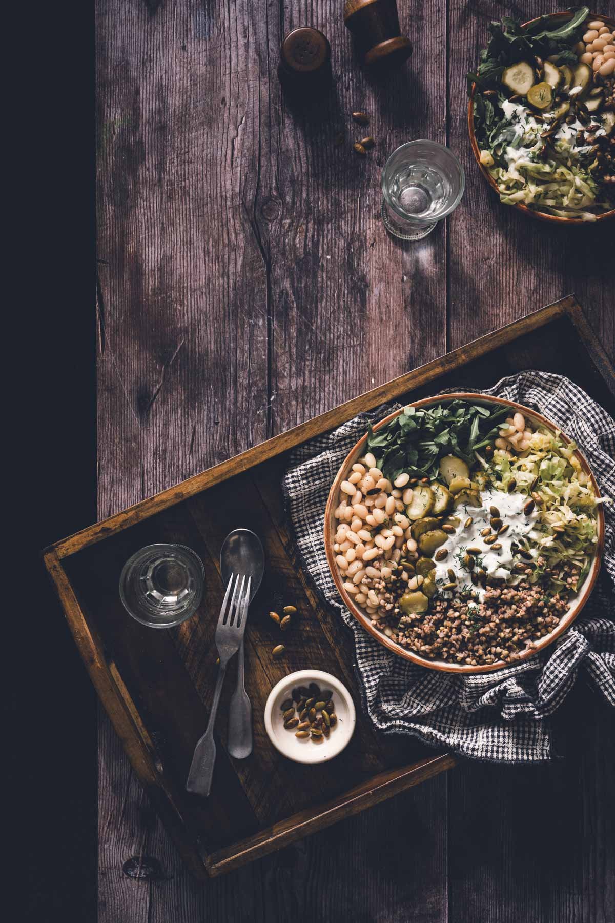 buckwheat bean bowl in a serving bowl on a serving tray, glass with water