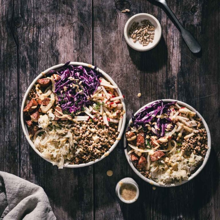 two buckwheat bowls with kielbasa, dish with sunflower seeds, dish with dressing