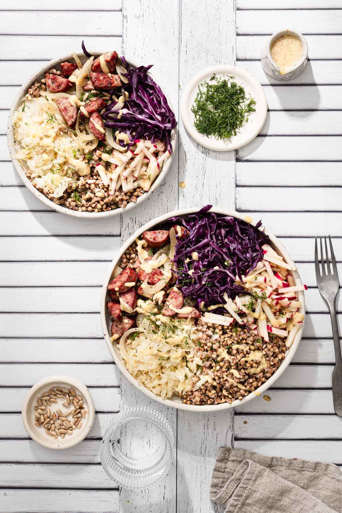 two buckwheat bowls served , utensils, napkin, dish with fresh dill