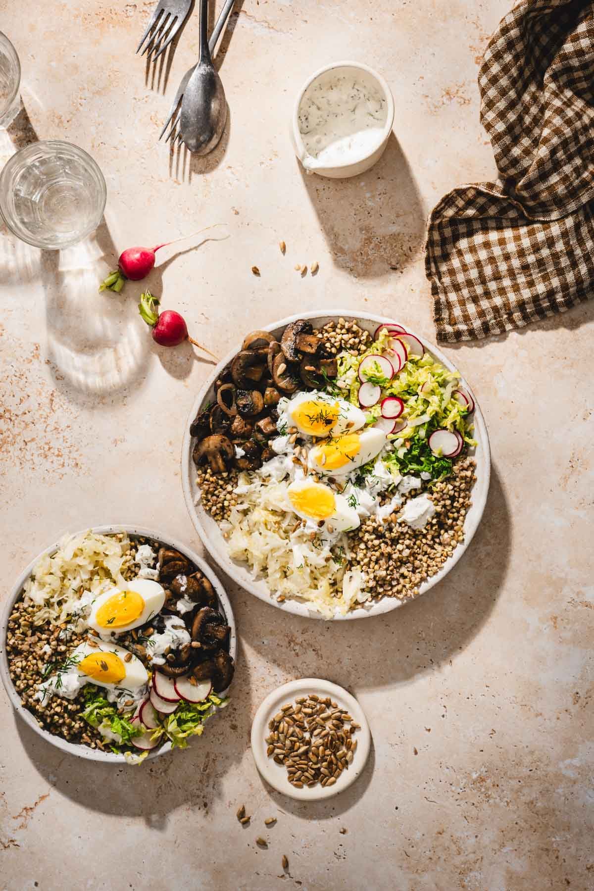 serving bowls with mushroom and buckwheat, napkin, glasses with water