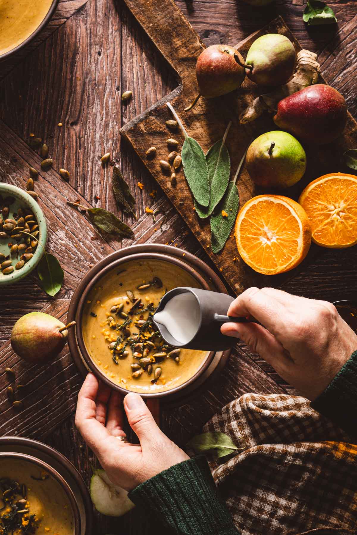hands in frame adding cream to the soup