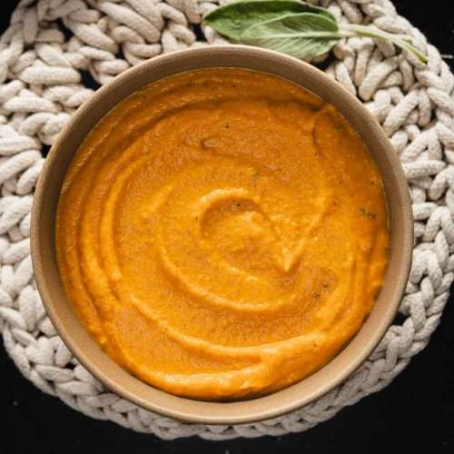 butternut sauce in a bowl, sage leaves and side dish with salt