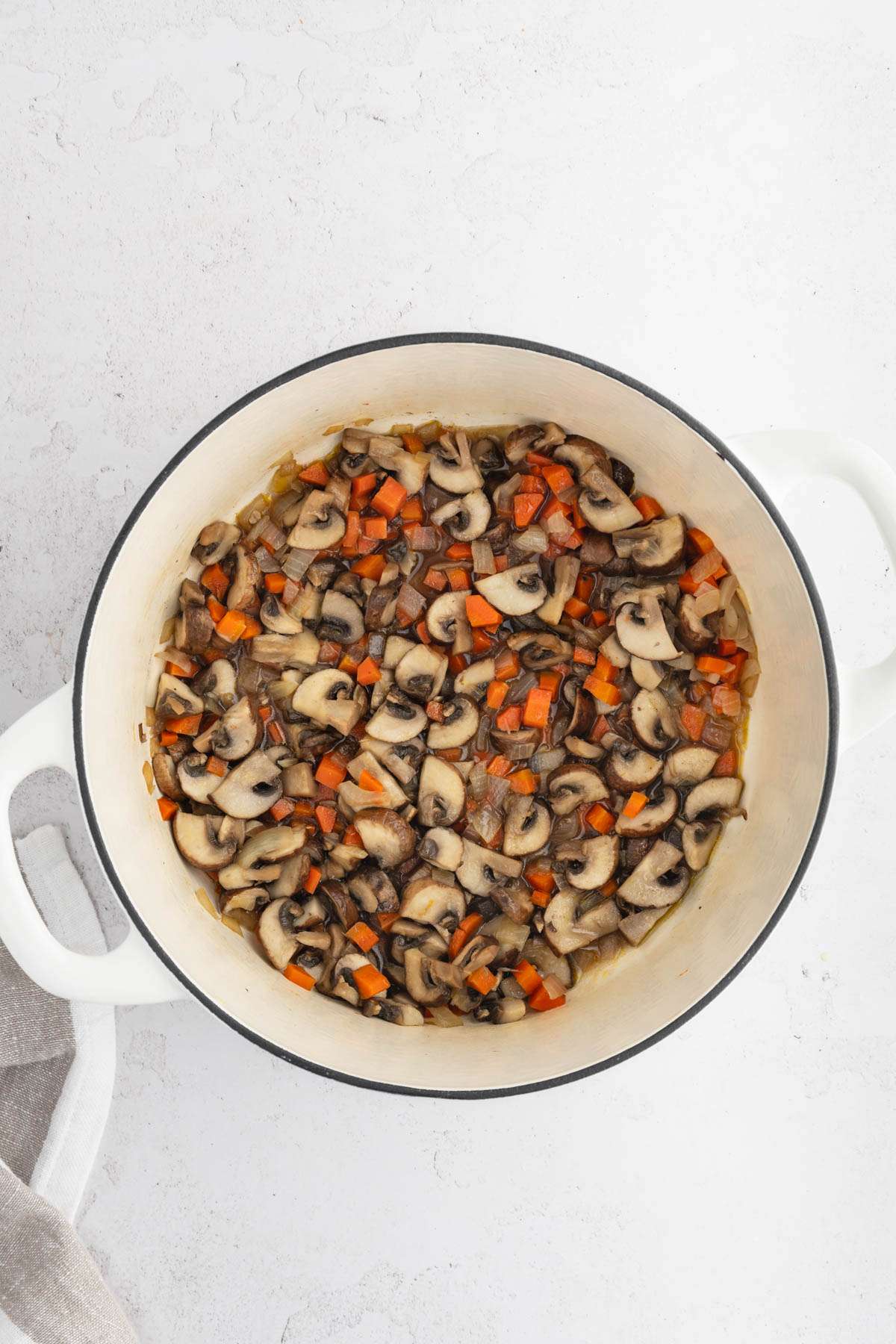 cooking pan with cooked mushrooms, onion and carrots