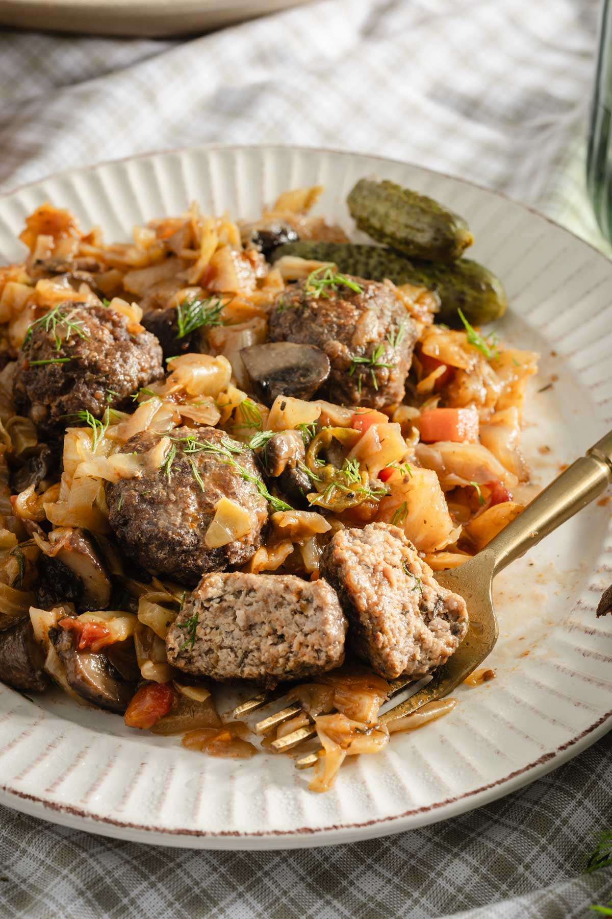 plate with smoked cabbage and meatballs, fork