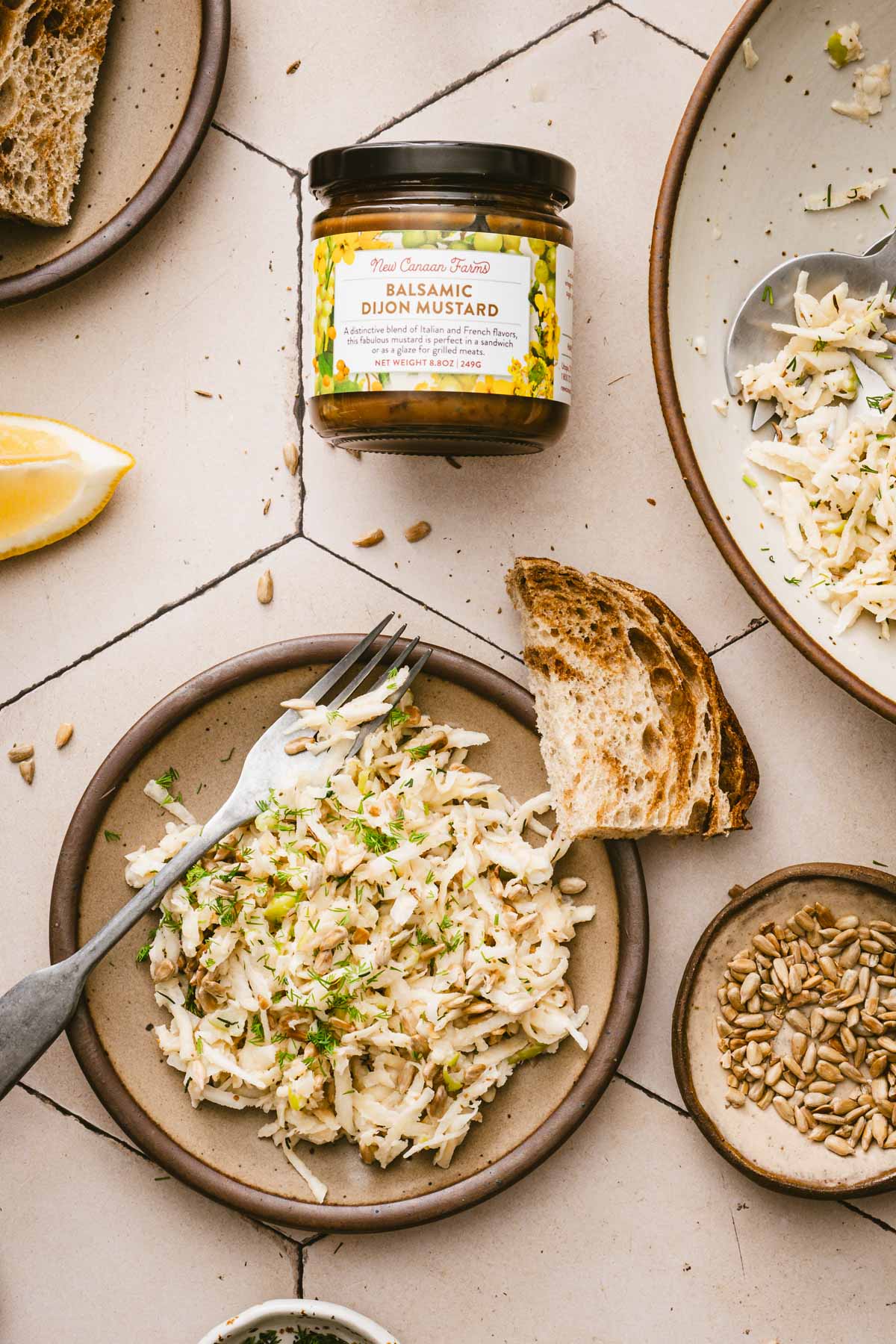 finished salad on a serving plat, jar of Balsamic Dijon Mustard