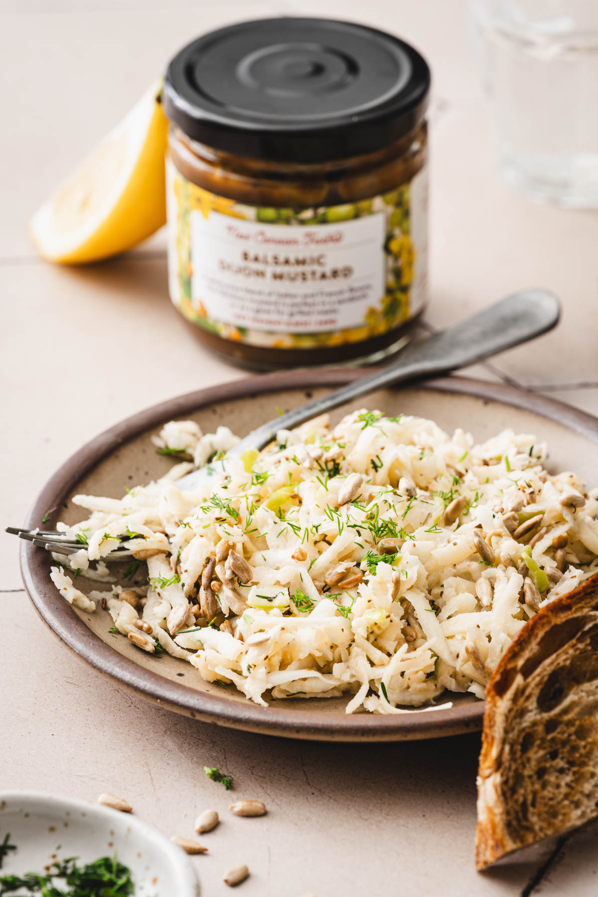 plate with the salad, jar with mustard, lemon wedge