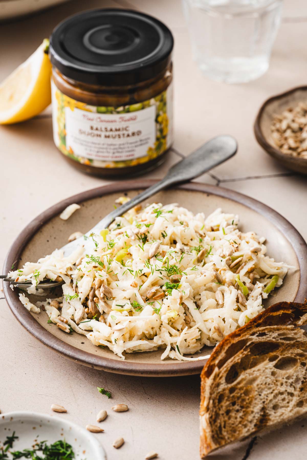 plate with the salad, jar with mustard, lemon wedge,dish with sunflower seeds