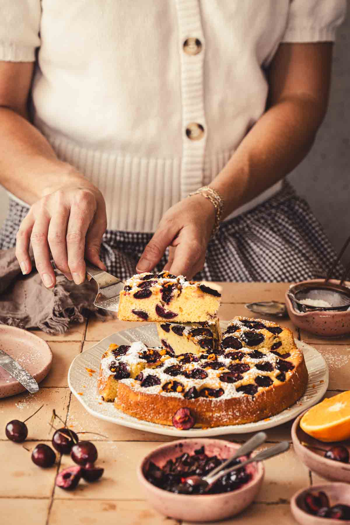 hands in frame holding spatula and serving the cake