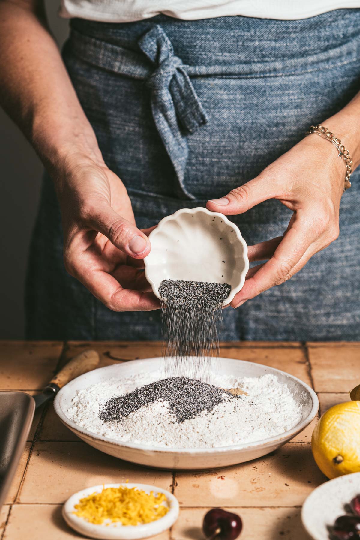 hands in frame adding poppy seeds
