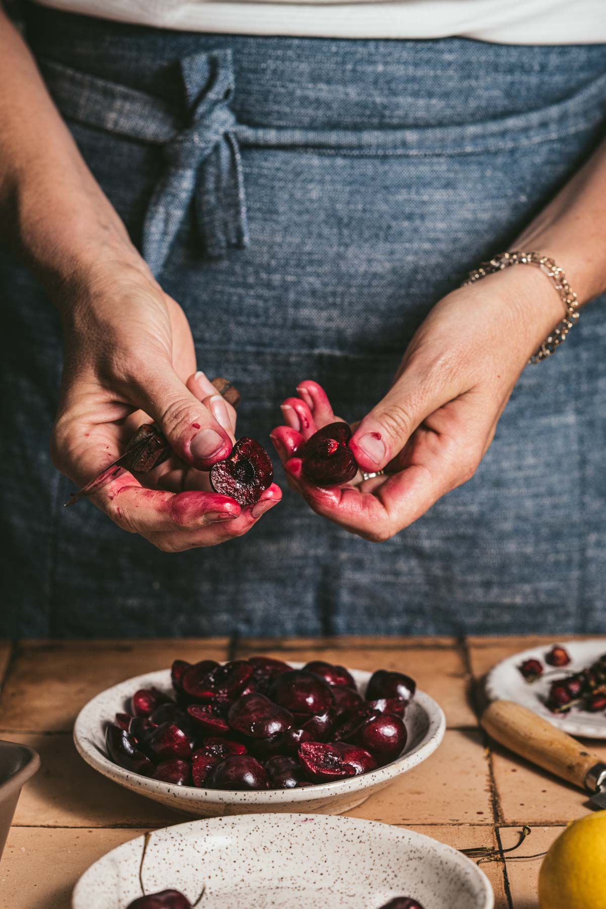 hands in frame pitting cherries