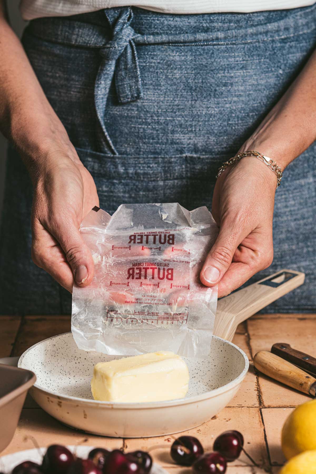 hands in frame adding butter to a skillet